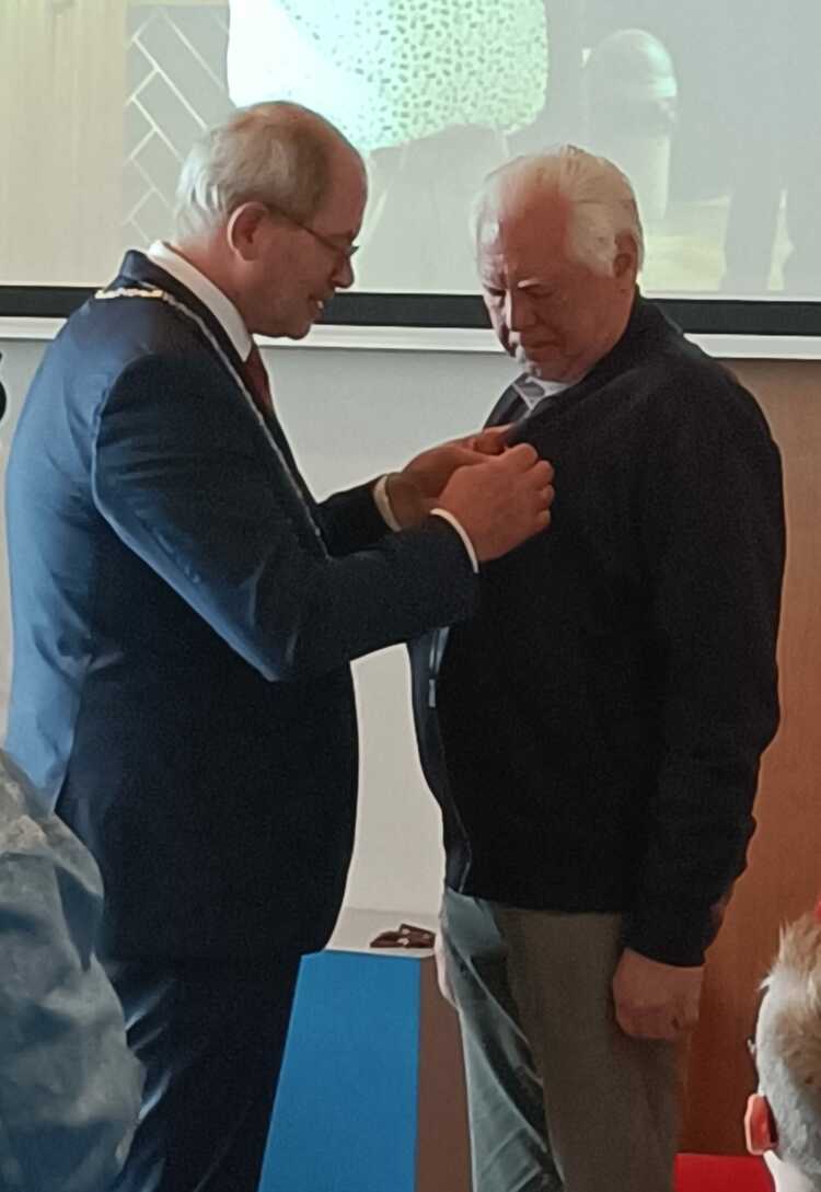 Jan Pol krijgt een lintje opgespeld van burgemeester Loohuis, als lid van de orde van Oranje Nassau